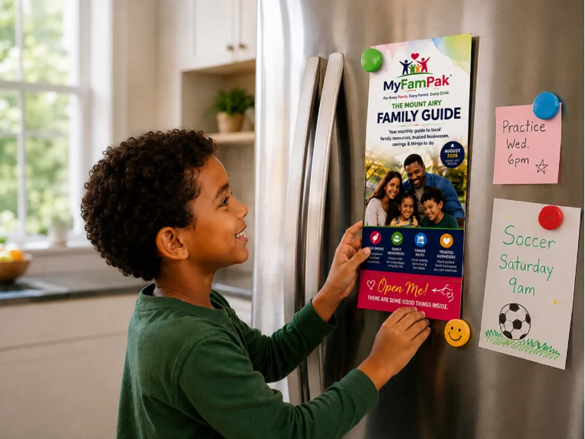 A boy putting the MyFamPak Family Guide on the refrigerator door with magnets